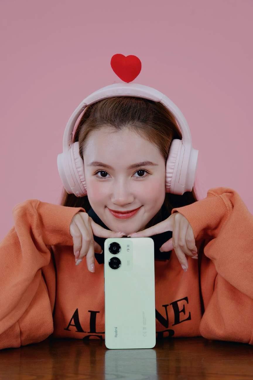 A person wearing headphones and holding a phoneDescription automatically generated
